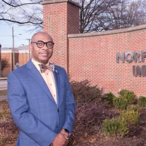 Dr. Juan Alexander standing on HBCU campus in front of brick building