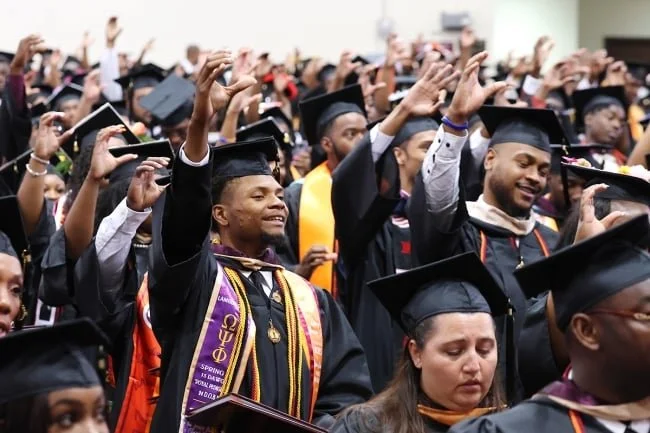 Claflin University graduates celebrating in caps and gowns at commencement ceremony