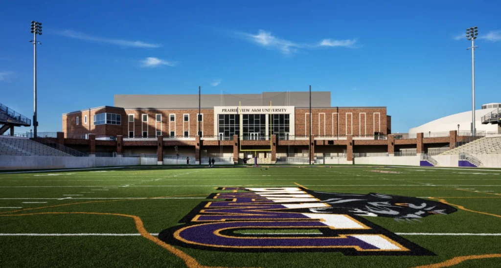 HBCU football stadium with athletic facility building and team logo on field